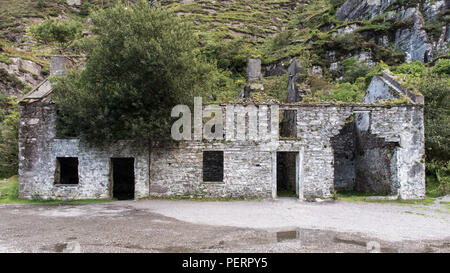 Ruined cottages beside the mountain pass road at Augher Lake in the Gap of Dunloe, nestled beneath the Macgillycuddy Reeks mountains in Ireland's Coun Stock Photo