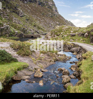 The River Loe and narrow mountain pass road wind through the steep valley of the Gap of Dunloe, nestled in the Macgillycuddy's Reeks mountains of Irel Stock Photo