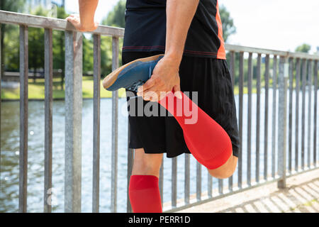 male runner in compression calf sleeve run over rocks Stock Photo - Alamy