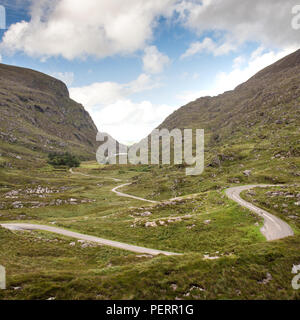 A narrow lane winds through the mountain pass in the Gap of Dunloe, nestled in the Macgillycuddy's Reeks mountains in Ireland's County Kerry. Stock Photo