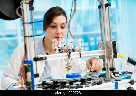 female student or laboratory assistant in the automation laboratory is debugging the work of the 3d printer. 3d printer is a device for modeling objec Stock Photo