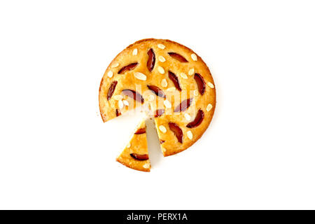 Cut homemade plum cake, glazed with victoria plum jam and decorated with roasted almond slivers and be a slice, isolated on white background. Stock Photo
