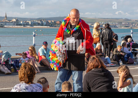 Crowds flock to watch the Weymouth carnival, on  a beautiful warm summers day. Stock Photo