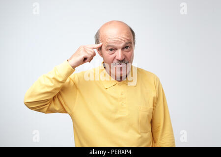 Closeup portrait of angry european man gesturing with his finger against his temple. are you crazy concept Stock Photo