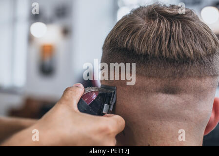 Haircut men Barbershop. Men's Hairdressers barbers. Barber cuts the client machine for haircuts. Stock Photo