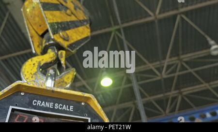 RUSSIA, ANGARSK - JUNE 8, 2018: Industrial type 5000 kg digital weight scale hanging on hook of crane, with clipping path. Manufacture of plastic water pipes factory. Stock Photo