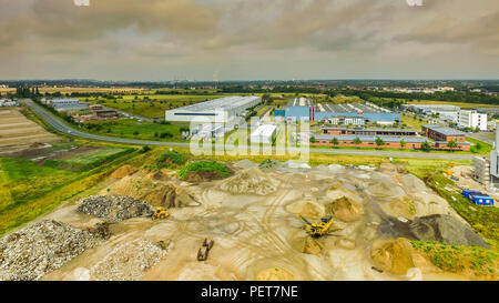 Slightly alienated aerial view of an industrial area, with a warehouse for building materials in the foreground, large factory buildings and warehouse Stock Photo