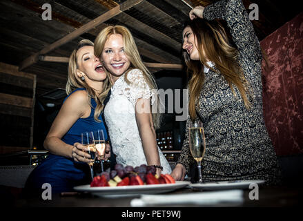 Party girls in a restaurant celebrating with drinks and champagne Stock Photo