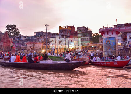 Indian people and tourists on boats at Dashashwamedh Ghat on Ganges river at evening Stock Photo