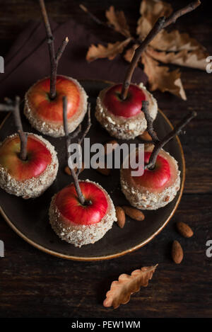 Homemade Caramel Apples on a Stick for Autumn holidays on rustic wooden background. Organic Snack - Caramel Apples with Almonds. Stock Photo
