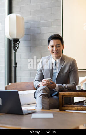 Confident businessman drinking tea Stock Photo