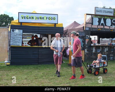 'Vegan Junk Food' stall at Green Man Festival, Wales, two men with child in cart in front of stall, vegan fast food Stock Photo