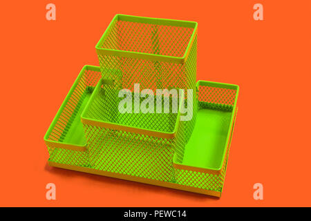 green empty pencil holder on an orange surface Stock Photo