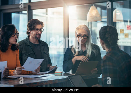 Business team of meeting around a table in office. Group of business man and woman discussing work in office. Stock Photo