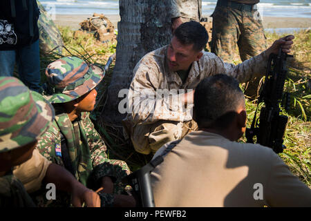 U.S. Marine Corps Cpl. Dustin Dooley, top, a reconnaissance man with 2nd Battalion, 4th Marine Regiment, speaks to Malaysian soldiers during Landing Force Cooperation Afloat Readiness and Training (LF CARAT) 2015 at Tanduo Beach, East Sabah, Malaysia, Aug. 16, 2015. LF CARAT is meant to strengthen, increase the interoperability in amphibious planning and operations and the core skill sets between the United States and the nations of Indonesia, Malaysia, and Thailand. (U.S. Marine Corps photo by MCIPAC Combat Camera Lance Cpl. Sergio RamirezRomero/Released) Stock Photo