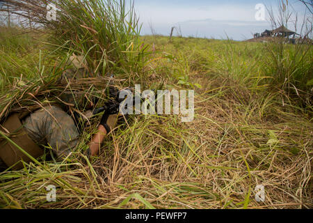 U.S. Marine Corps Lance Cpl. Devin Fairbanks, a rifleman with Golf Company, 2nd Battalion, 4th Marine Regiment, post security before conducting a joint simulated amphibious assault with the Malaysian Army during Landing Force Cooperation Afloat Readiness and Training (LF CARAT) 2015 at Tanduo Beach, East Sabah, Malaysia, Aug. 19, 2015. LF CARAT is meant to strengthen, increase the interoperability in amphibious planning and operations and the core skill sets between the United States and the nations of Indonesia, Malaysia, and Thailand. (U.S. Marine Corps photo by MCIPAC Combat Camera Lance Cp Stock Photo