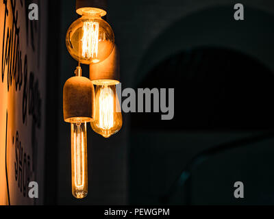 Different types of vintage glowing light bulbs on black. Edison lamps Stock Photo