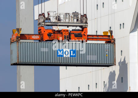 ROTTERDAM - MAR 16, 2016: Crane operator placing a container in a cargo ship the Port of Rotterdam. Stock Photo