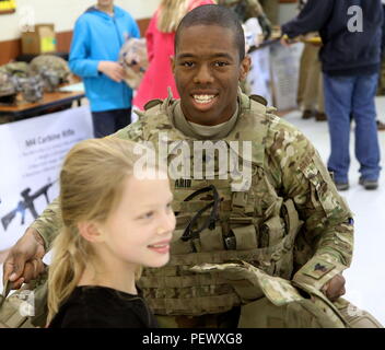 Spc. Donzell Sahid, an infantryman with 3rd Battalion, 69th Armor Regiment, shows a student how the Improved Outer Tactical Vest works during the Carver Elementary School Career Fair in Richmond Hill on Feb. 5, 2016. Stock Photo