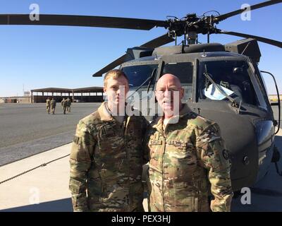 West Virginia Army National Guard Chief Warrant Officer 4 Lawrence Copley and his son Chief Warrant Officer 2 Joseph Copley, pilots from 2nd Battalion, 104th Aviation Regiment, 40th Combat Aviation Brigade, get some quality time together shortly after Joseph’s promotion at Camp Buehring, Kuwait, Jan. 30. The Copleys deployed with the 40th CAB to Kuwait in December. Stock Photo