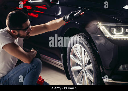 man checks the polishing with a torch Stock Photo