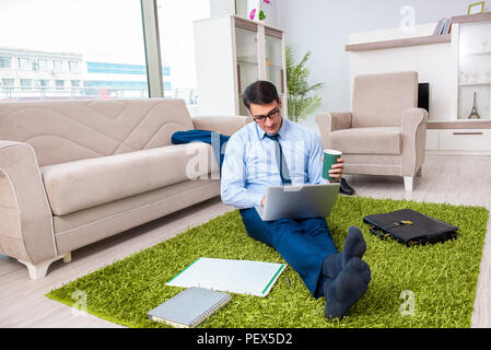 Businessman taking work home and working overtime Stock Photo