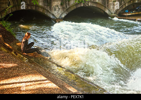 MUNICH, GERMANY - JULY 24, 2018 -  Munich, surfer girl in diving  suit ready to practice on the artificial wave on the Eisbach, small river Stock Photo