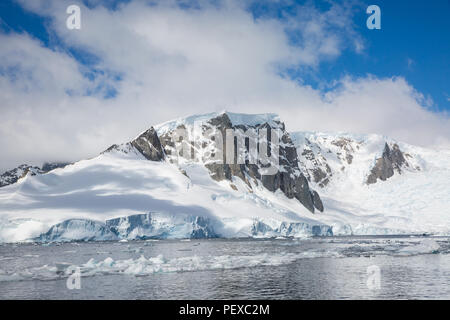 icecaps in the Antarctica with iceberg in the ocean swimming around and melting in the sea Stock Photo