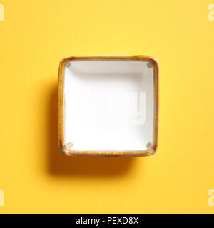 White dish isolated on yellow background Stock Photo
