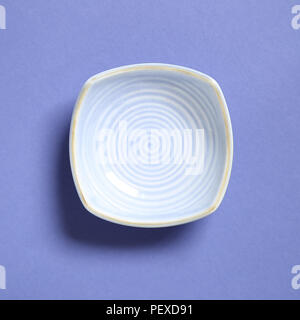 Blue dish isolated on purple background Stock Photo