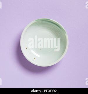 Green dish isolated on purple background Stock Photo
