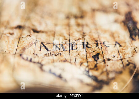 View through magnifier on old map, showing "America" word. Stock Photo