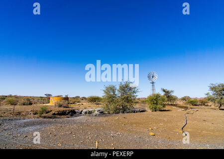 Windmill in the desert of namibia pumping water Stock Photo