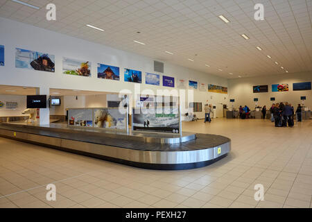 Empty baggage carousel at Svalbard Longyearbyen Airport Longyearbyen Lufthavn and tourists checking in for a flight Stock Photo