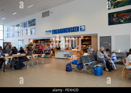 Passangers sitting in front of Svalbardkiosken souvenir shop at Svalbard Longyearbyen Airport Longyearbyen Lufthavn Stock Photo