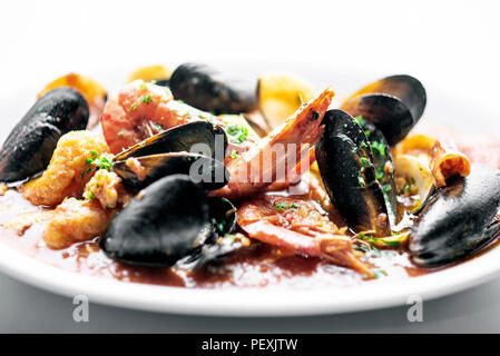 sicilian mixed fresh seafood stew with prawns mussels scallops and clams in spicy tomato sauce Stock Photo