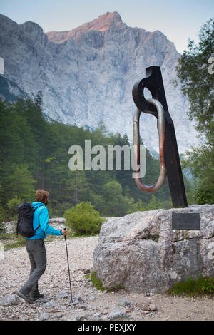 Mountain guide walking by monument of carabiner, Triglav, Slovenia Stock Photo