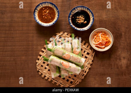 Vietnamese spring rolls - rice paper, lettuce, salad, vermicelli, noodles, shrimps, fish sauce, sweet chili, soy, lemon, veletables. Copy space. Asian Stock Photo