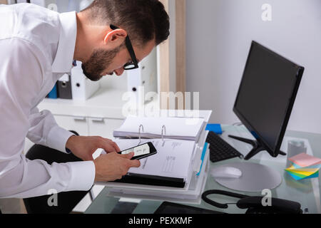 Side View Of A Young Businessman Taking Photo Of Bill On Smartphone Stock Photo