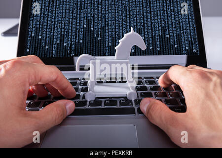 Close-up Of A Person's Hand With Trojan Horse Icon On Laptop Affected By Virus Stock Photo
