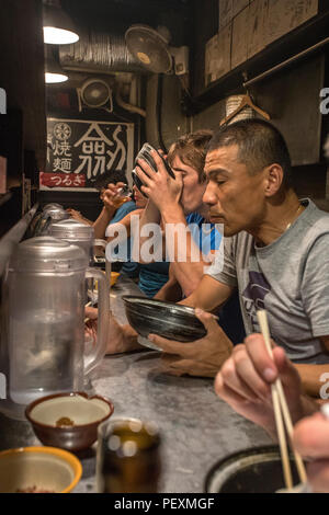 Tourists eating in ramen shop, Tokyo, Japan