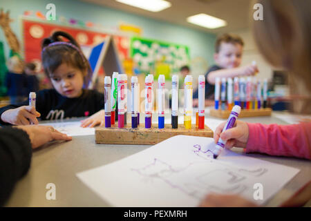 Children coloring in classroom Stock Photo