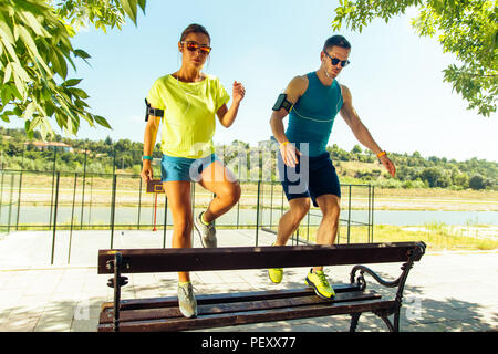 Muscular couple doing a leg stretching after running Stock Photo