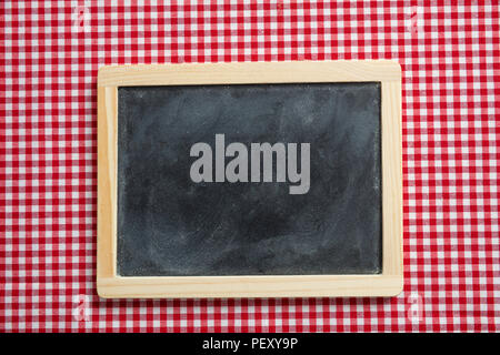 Menu concept. Blackboard with wooden frame on red checkered picnic tablecloth, space for text Stock Photo