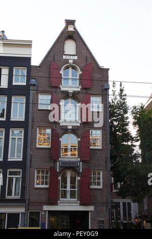 A traditional Amsterdam apartment building with red wooden window shutters Stock Photo