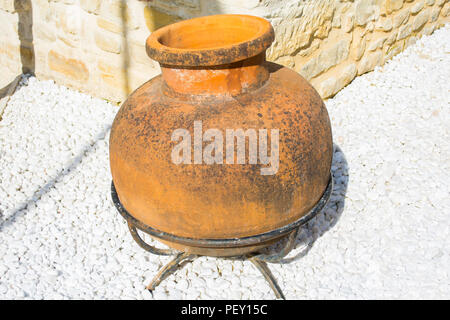 Stainless stell water bowl put on close lid of earthenware jar, big water jar on floor cement. Stock Photo