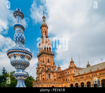 Seville Spain - July 15, 2018: Juxtaposition of blue and white ceramic azulejo tiles against one of the baroque sandstone tower at Plaza de Espana in  Stock Photo