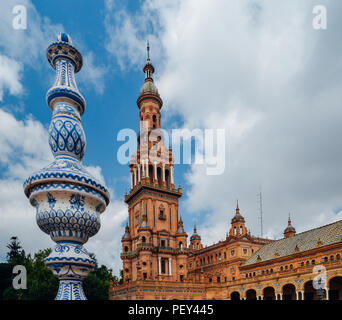 Seville Spain - July 15, 2018: Juxtaposition of blue and white ceramic azulejo tiles against one of the baroque sandstone tower at Plaza de Espana in  Stock Photo