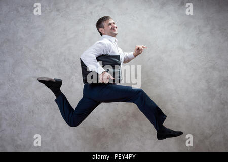 running businessman with briefcase on gray background Stock Photo