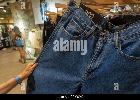 High-waisted "mom jeans" on a rack in an Urban Outfitters retail store in Herald Square in New York on Thursday, August 9, 2018. Retailers are hoping that a of 90's fashions such as fanny packs, mom jeans and other retro looks will raise their bottom ...